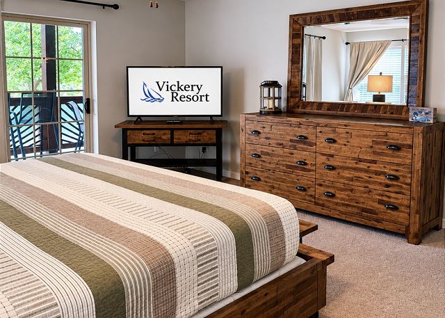 Primary bedroom with television and deck access
