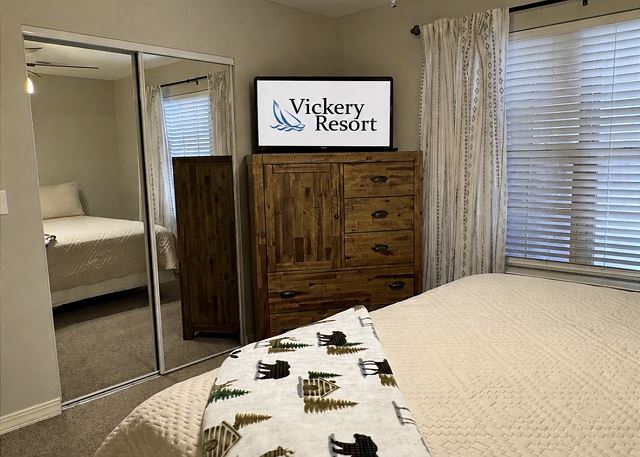 King bedroom with television and mirrored closet