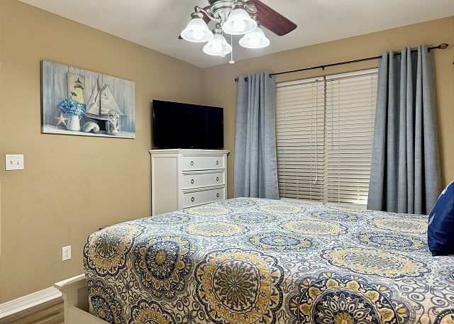 Queen bedroom with television in Condo A-3