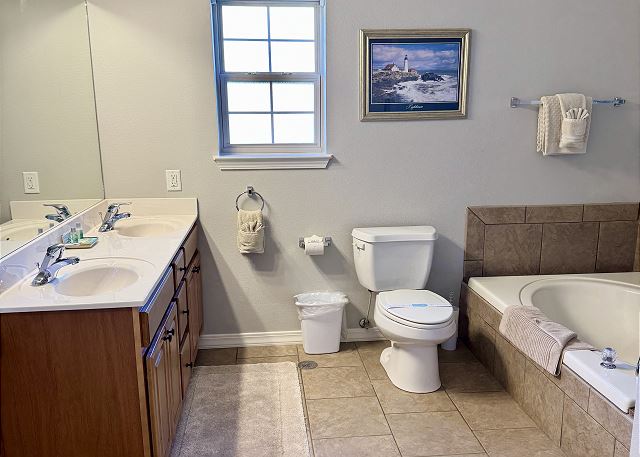 Primary bathroom jetted tub and vanity in Condo A-6