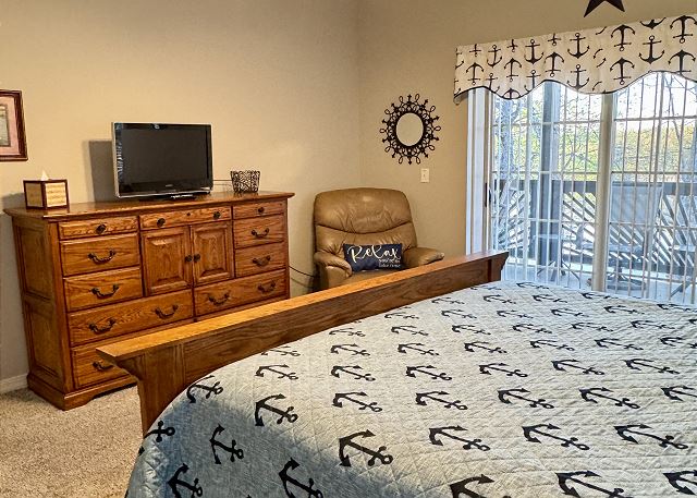 Primary king bedroom with television and balcony in Condo A-6