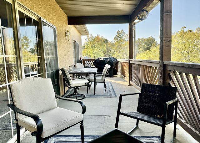 Covered balcony seating and lake view at Condo A-7