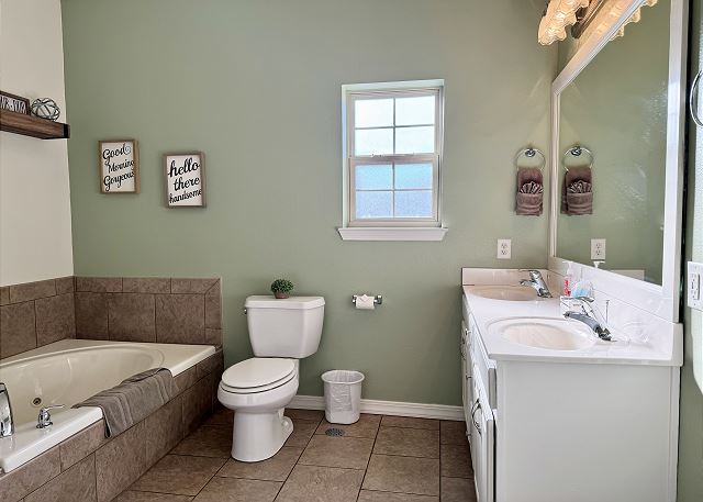 Primary bathroom jetted tub and vanity in Condo A-7