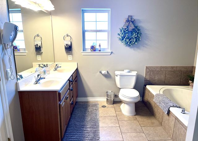Primary bathroom tub shower and vanity in Condo A-9