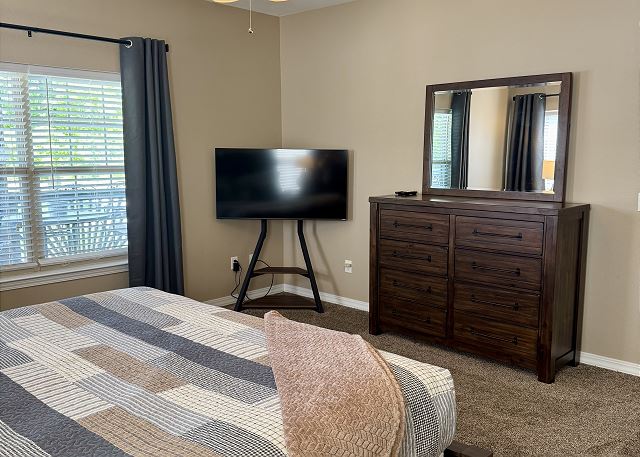 Primary bedroom with TV and patio access