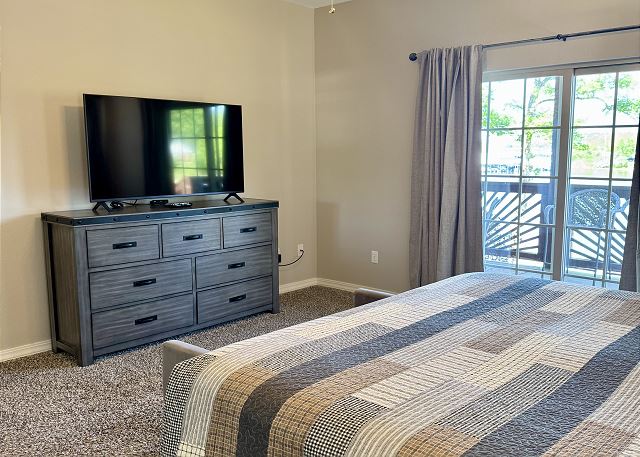 Primary bedroom with television and deck access