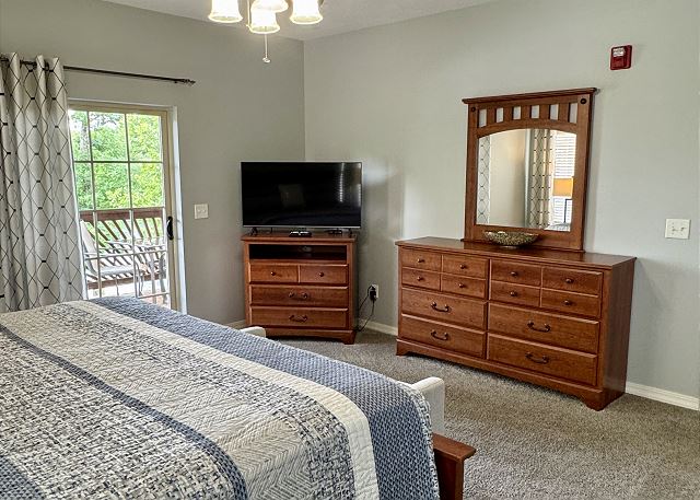 Primary bedroom with television and deck access in Condo B-4