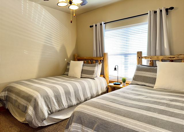 Primary bedroom with television and lake view in Condo B-8